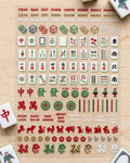 Mahjong nail art sticker sheet on a wood table with mahjong tiles: suits, winds, dragons, jokers, dice, zodiac animals, and phrases like Rack 'Em Up and About Bam Time
