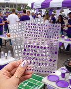 Hand holding the purple and white Northwestern nail sticker sheets at a tailgate, purple nails with letter stickers