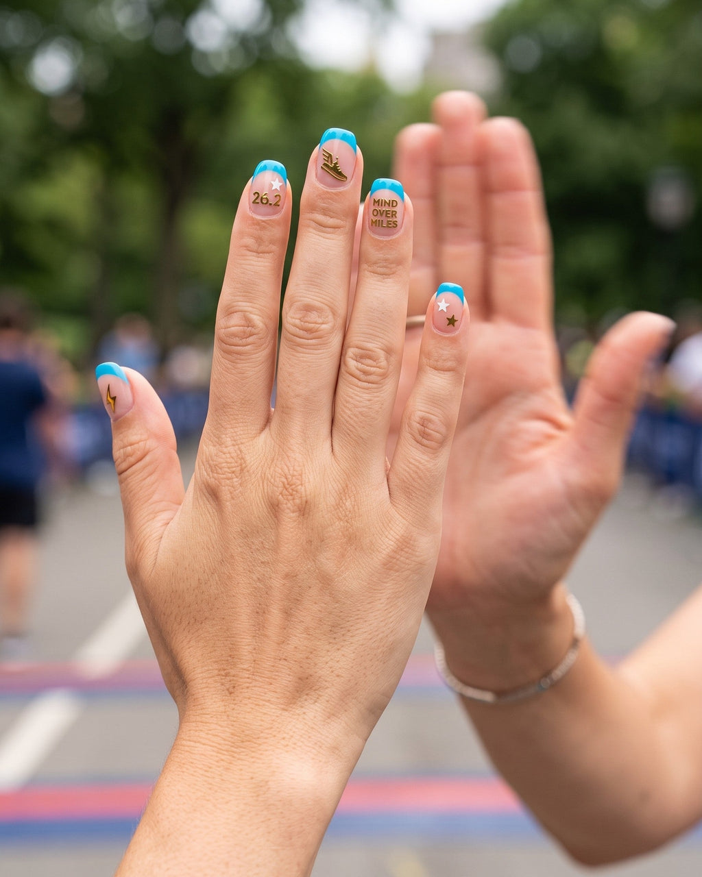 High five at a race finish with pool cyan french tips and running stickers