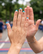 High five at a race finish with pool cyan french tips and running stickers