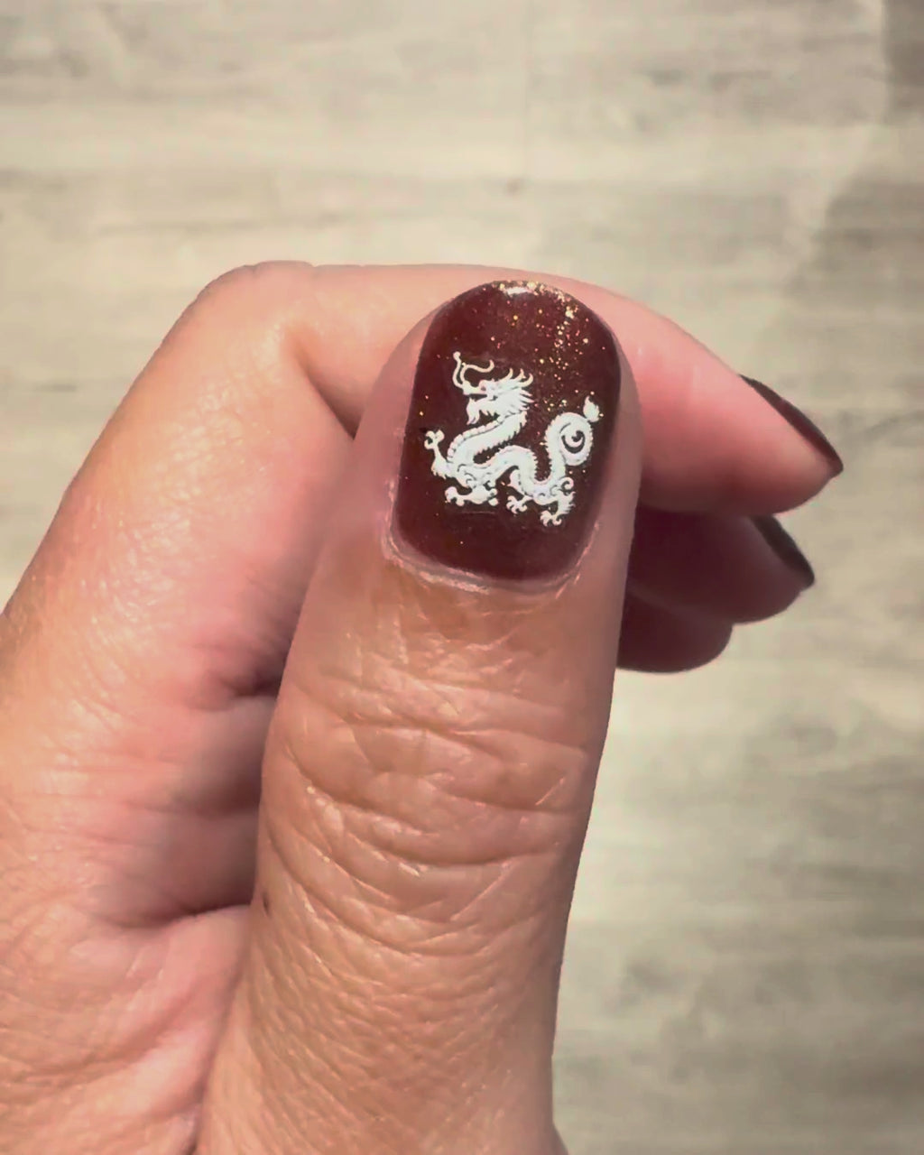 Close-up of a shimmer nail wearing a white dragon mahjong sticker